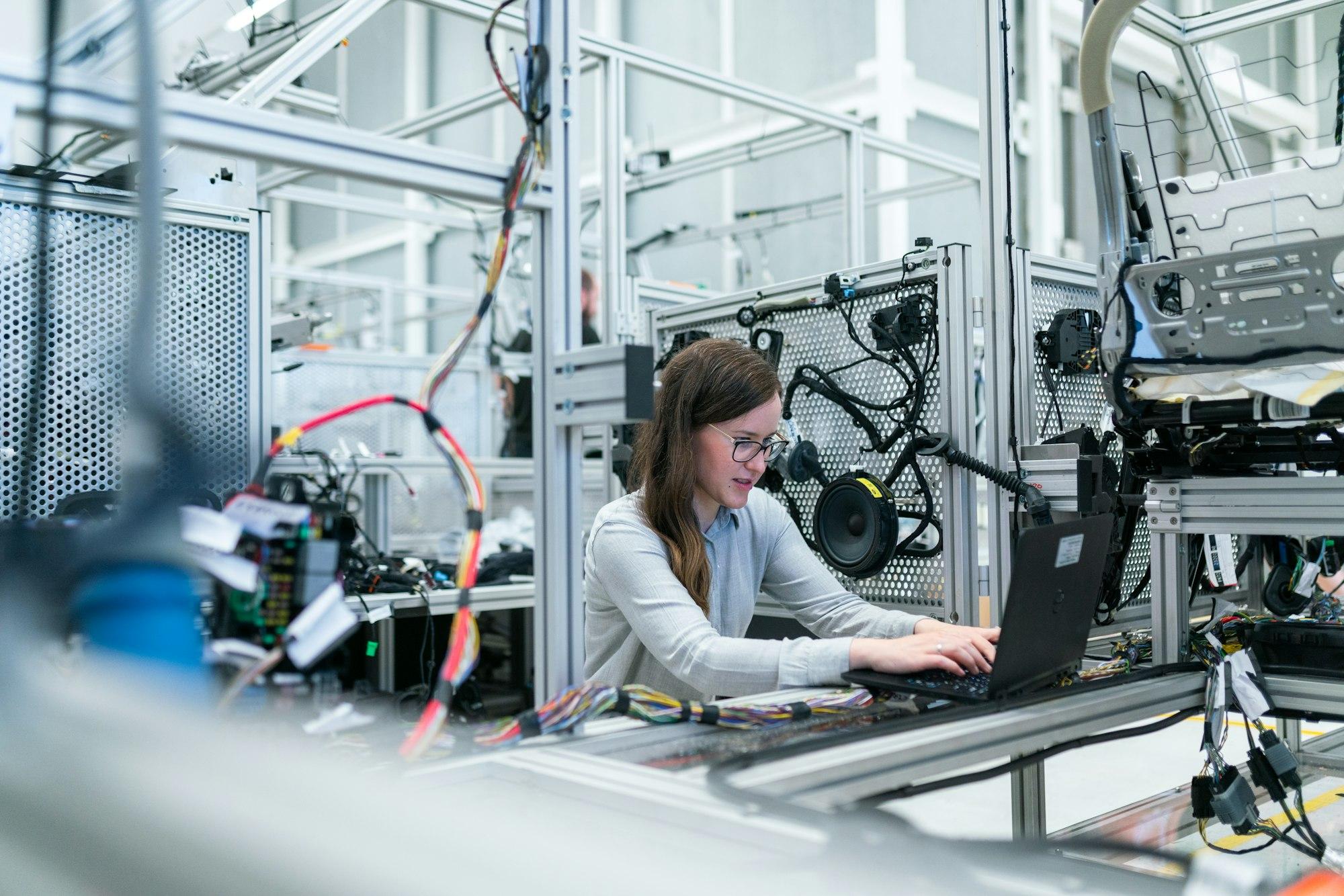 An engineer at a workstation on a production floor, inside a real operating business.