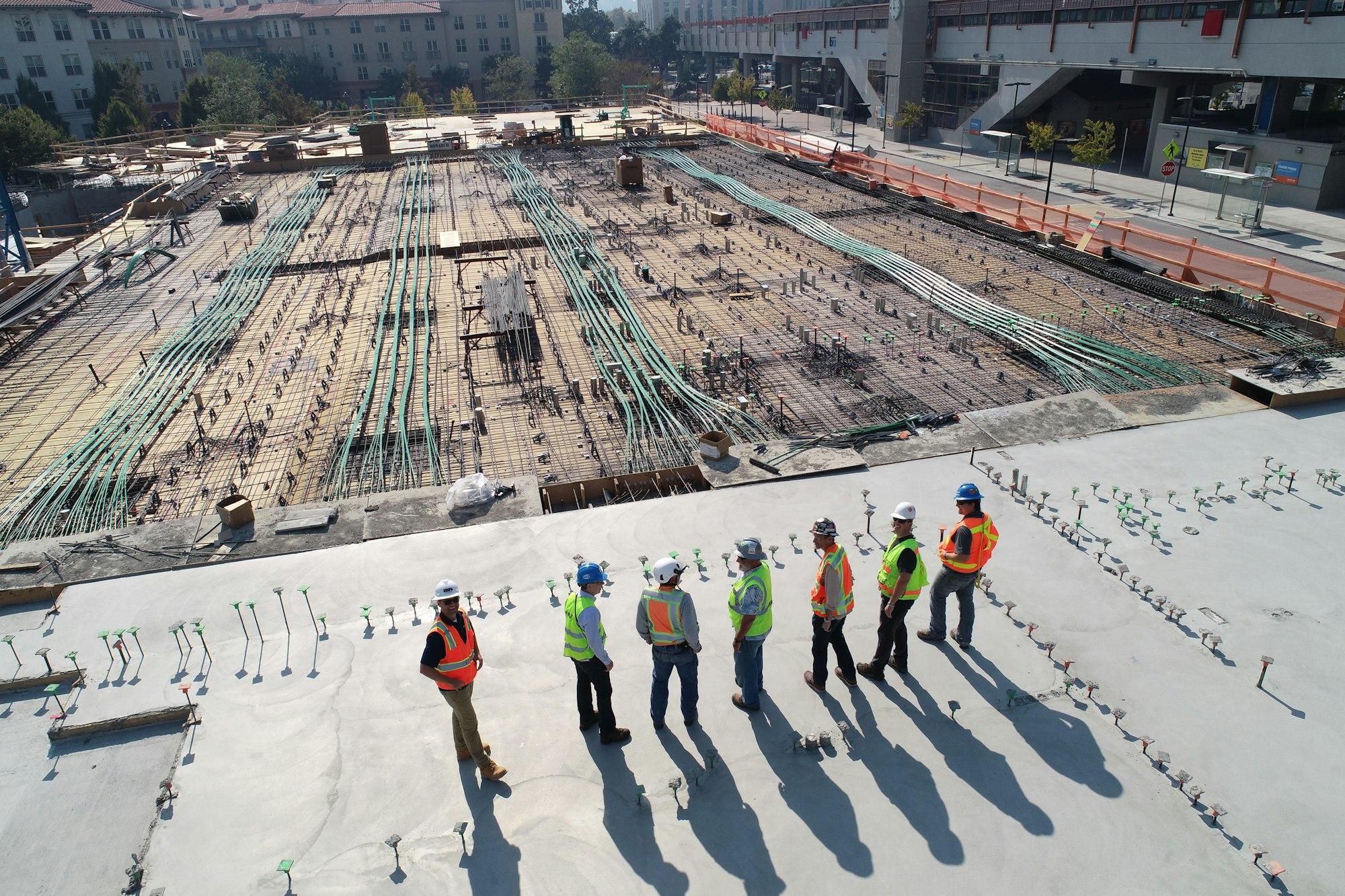 Aerial view of a construction site with a crew gathered on the slab.